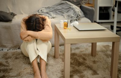 Depressed young woman sitting on the floor with her head buried. Mental Health concept Depressed young woman sitting on the floor with her head buried. Mental Health concept.