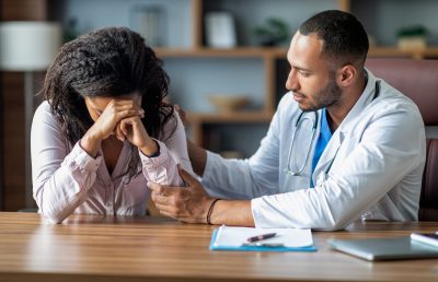 Attentive arabic doctor supporting sad black woman patient Attentive handsome arabic man doctor supporting sad black woman patient, upset african american lady crying while attending gynecologist at private clinic, suffering from infertility